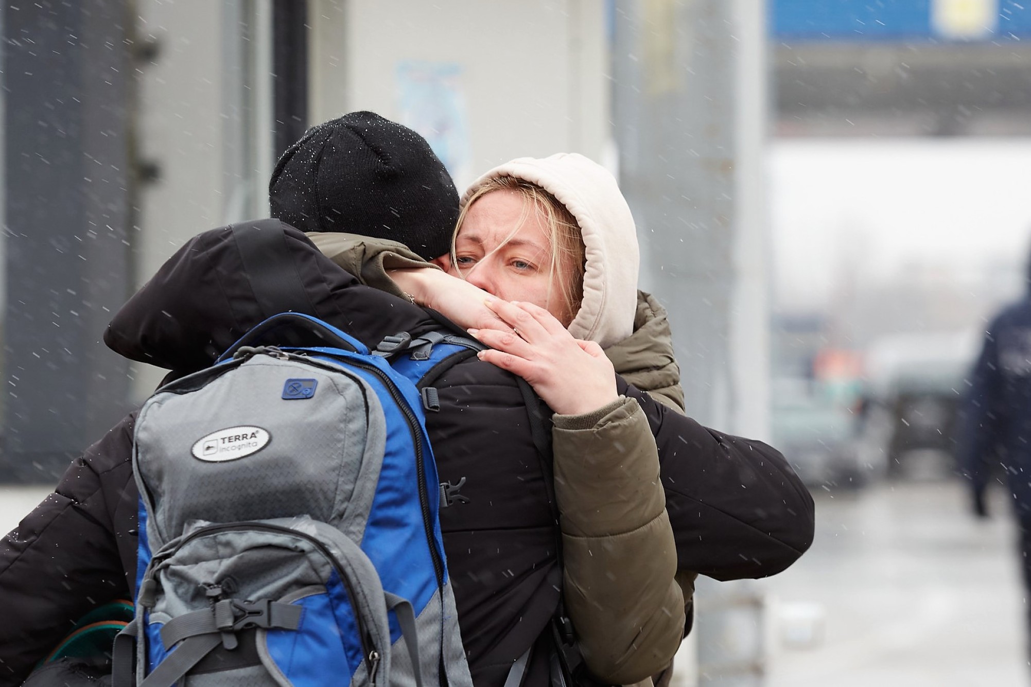 To flygtninge krammer hinanden i snevejr