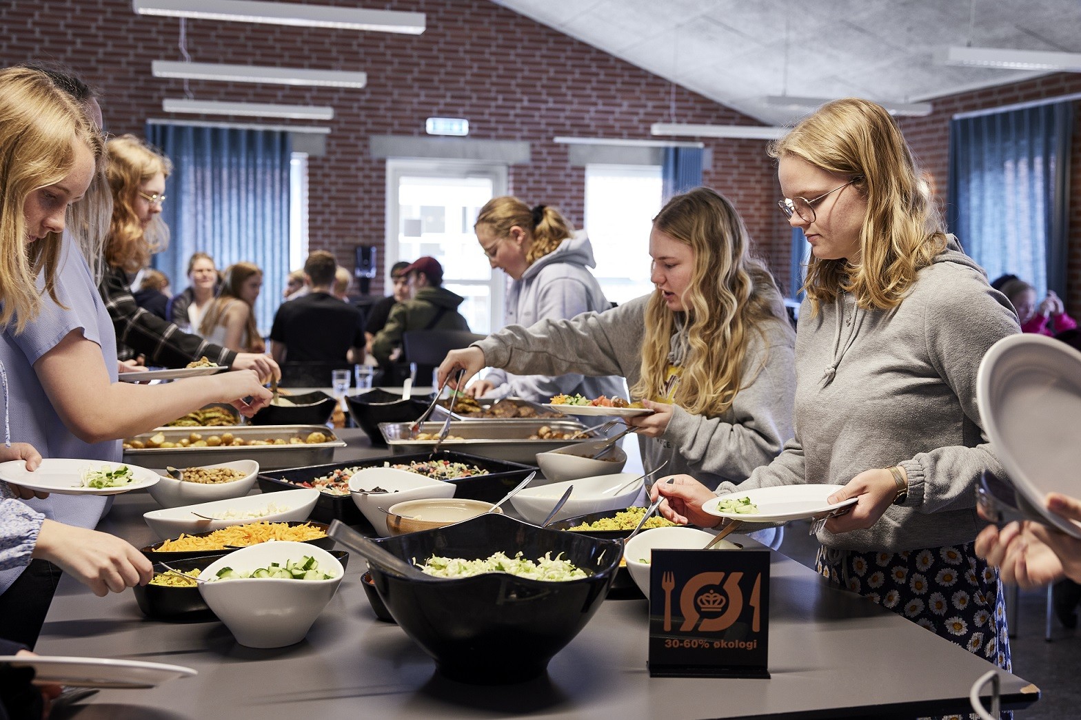 Efterskoleelever tager mad fra en buffet
