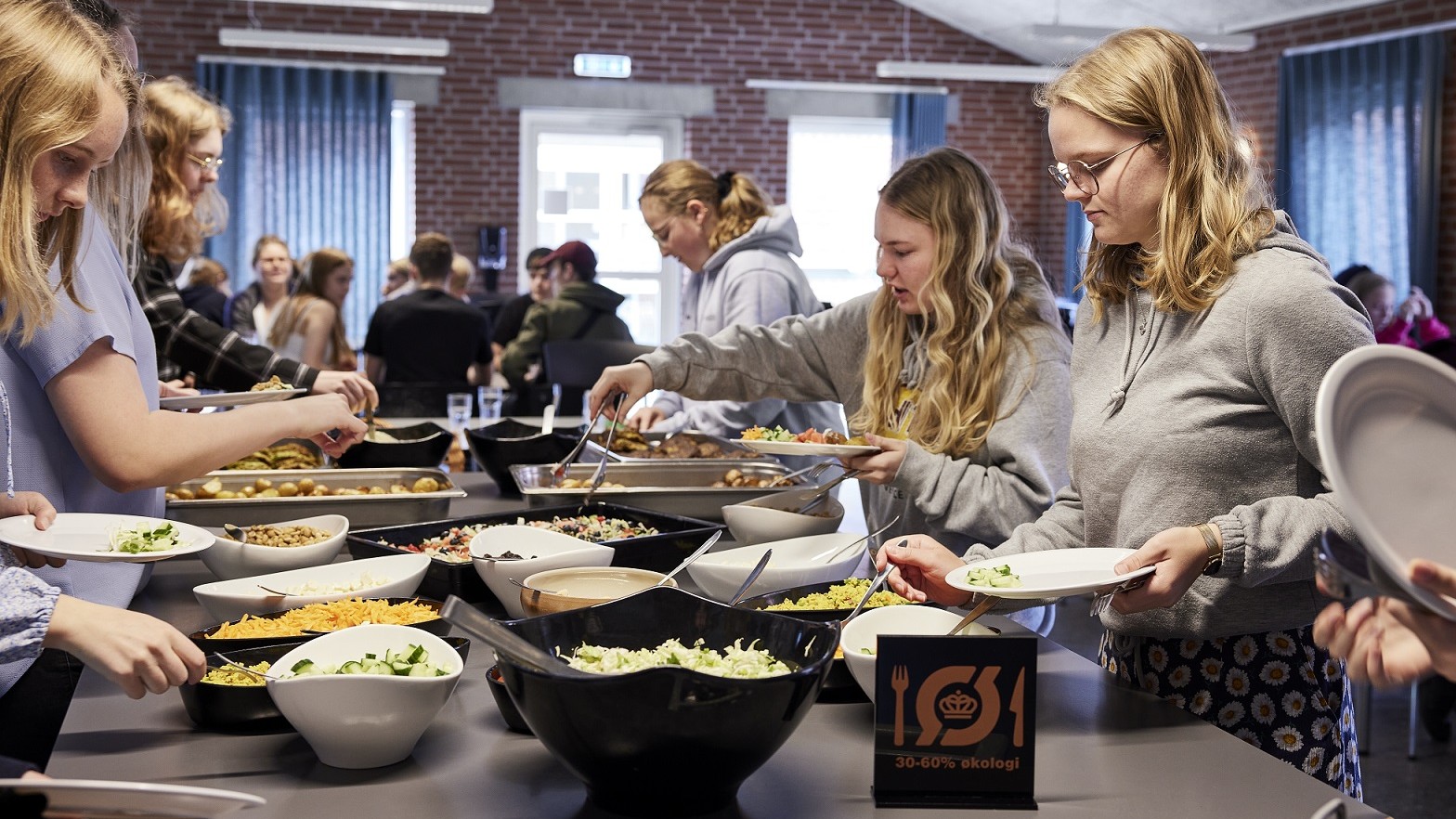 Efterskoleelever tager mad fra en buffet