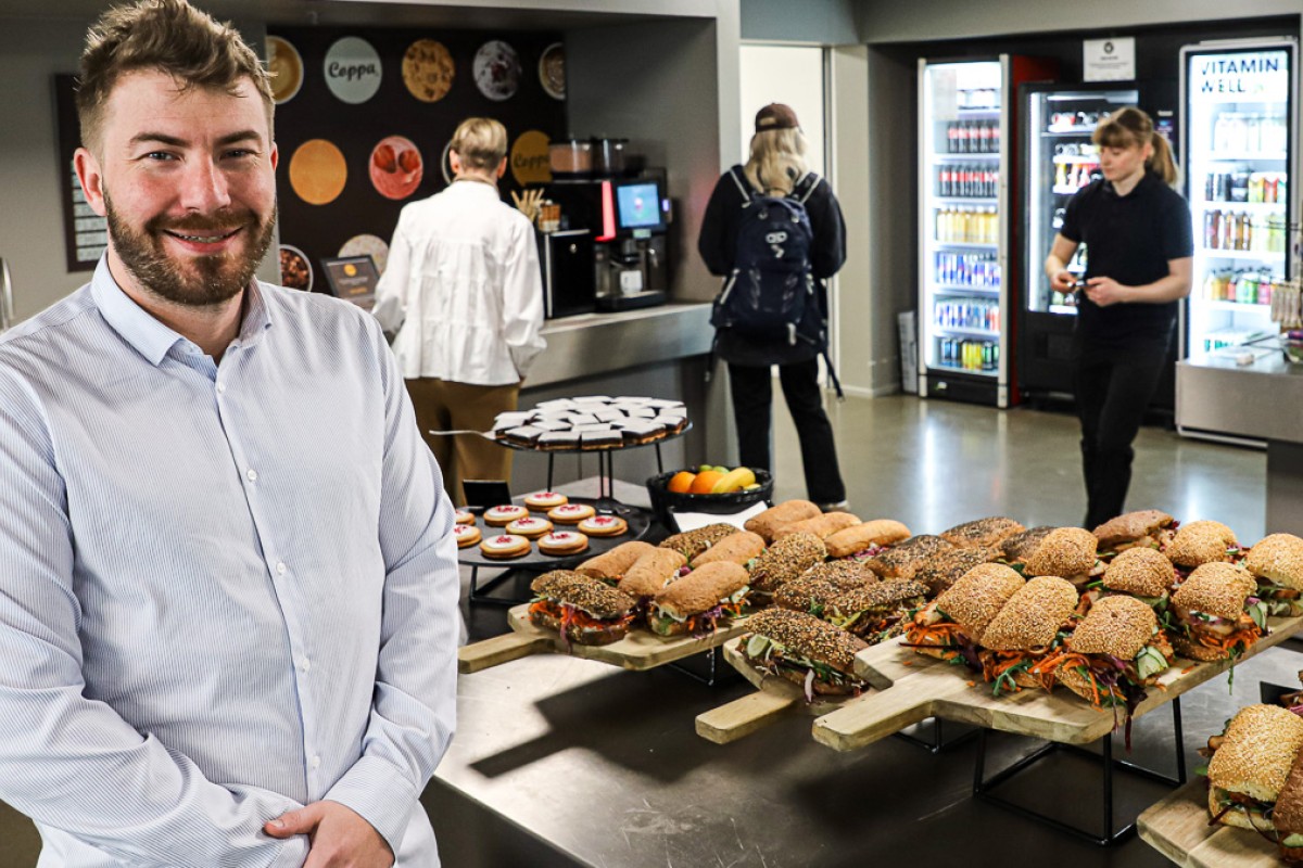 Karl Pirok står foran te serveringsbord med sandwiches