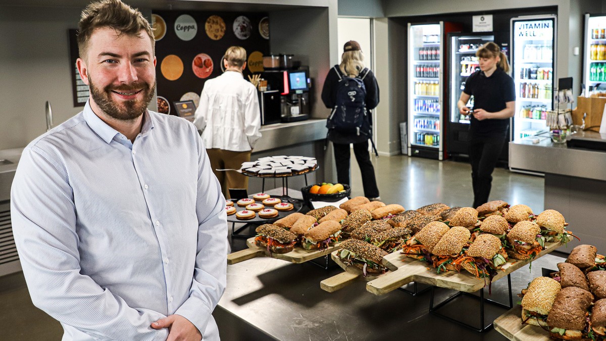 Karl Pirok står foran te serveringsbord med sandwiches