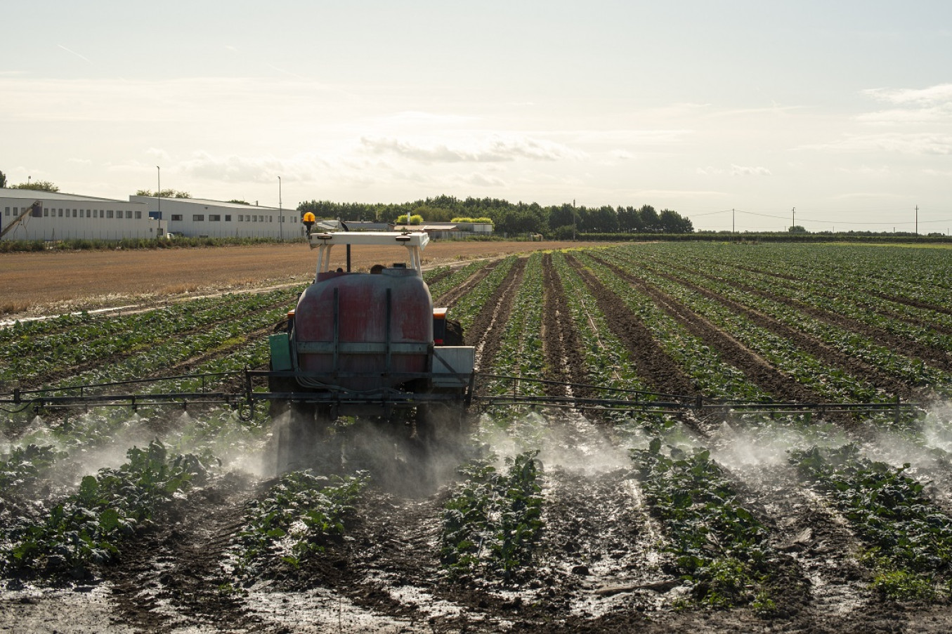 En traktor spreder pesticider på en mark