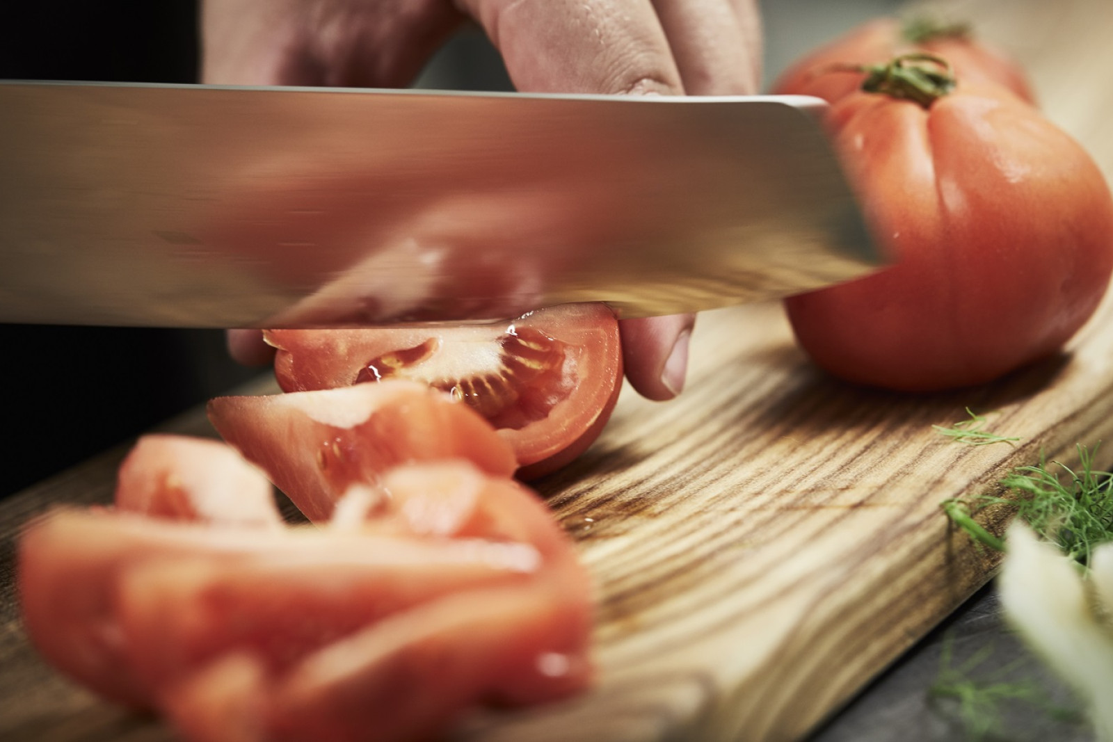 Kok skærer tomater i både