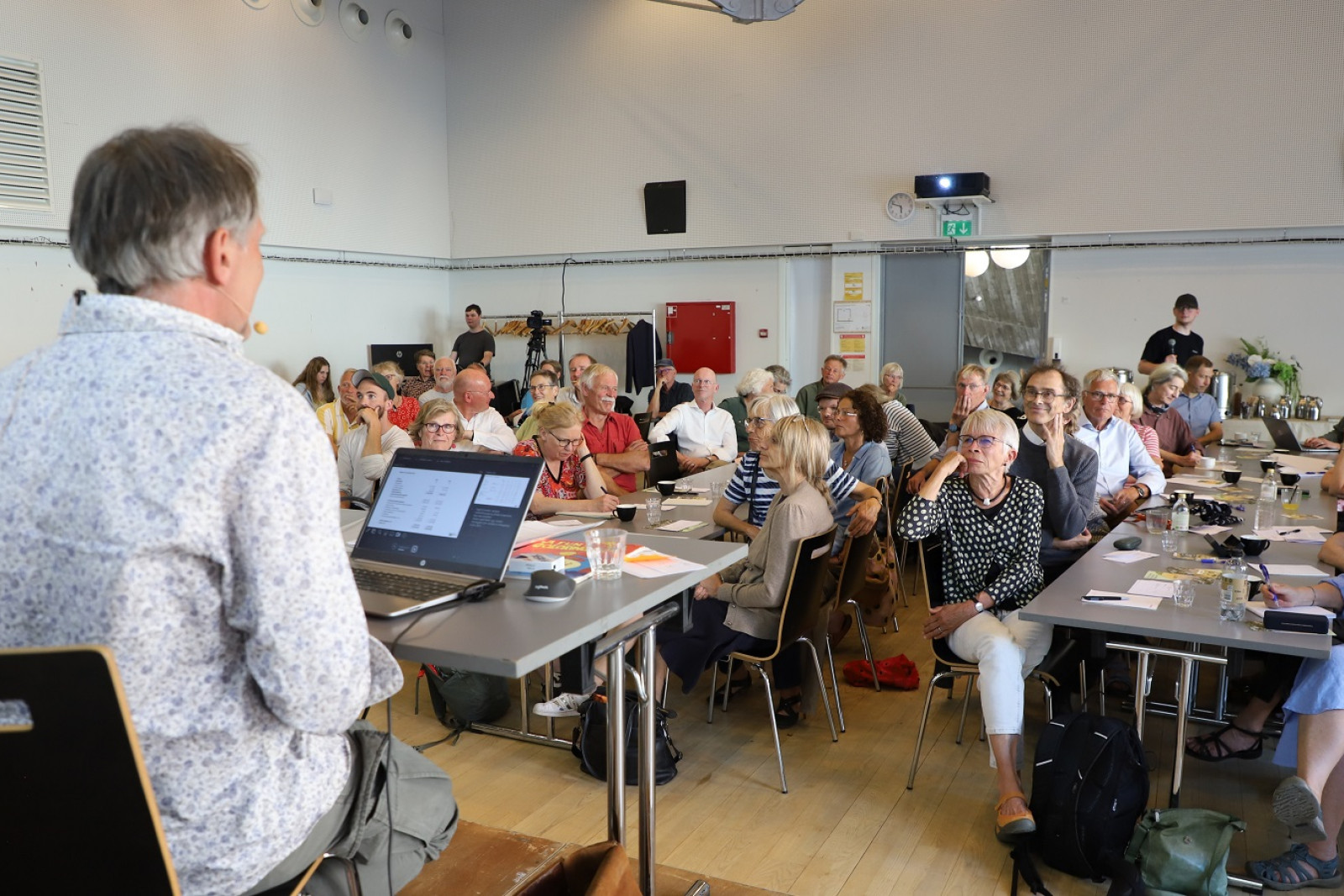Deltagerne ved generalforsamlingen i Dansk Økojord lytter til formandens beretning