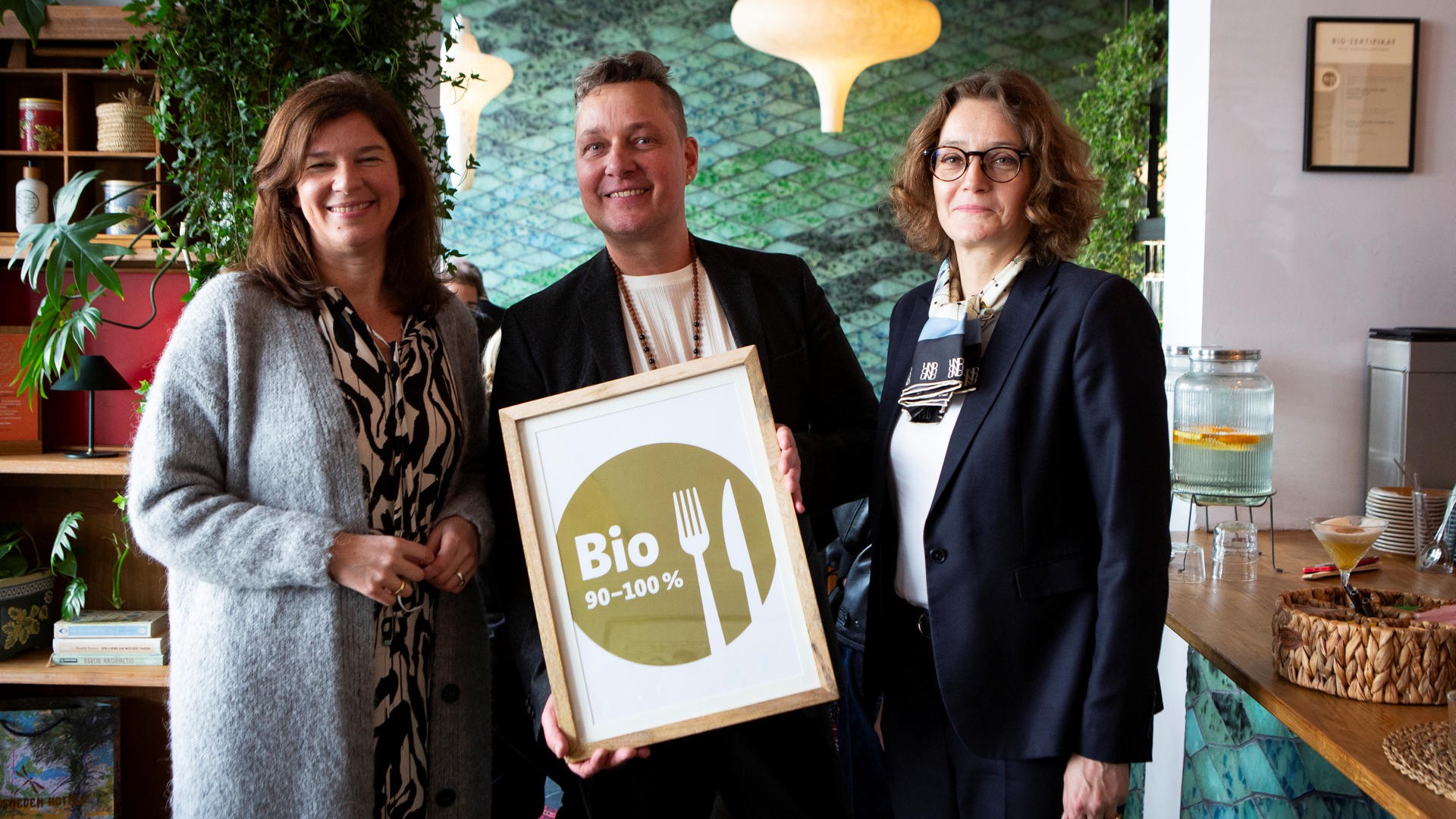 Dr. Ophelia Nick fra Die Grüne, hoteldirektør Nick Zilinski og Danmarks ambassadør Susanne Hyldelund ved overrækkelsen af guldmærket på hotel Lulu Guldsmeden i Berlin