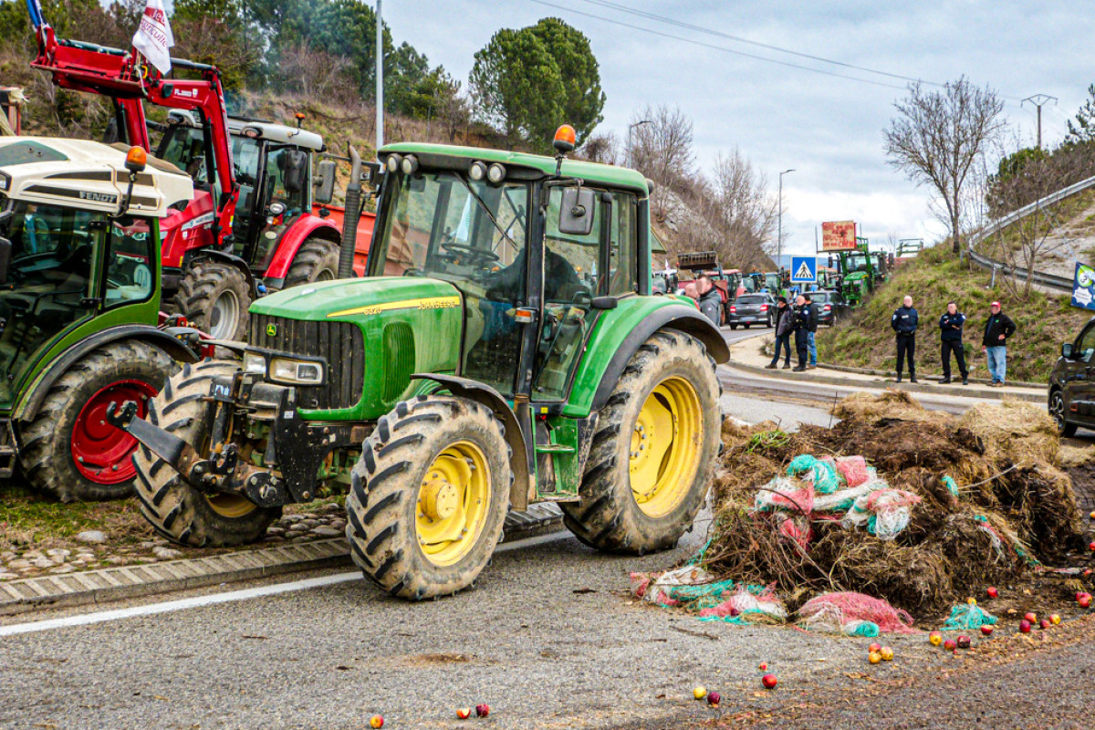 Traktorer og høballer blokerer en bjergvej som del af en landmandsprotest