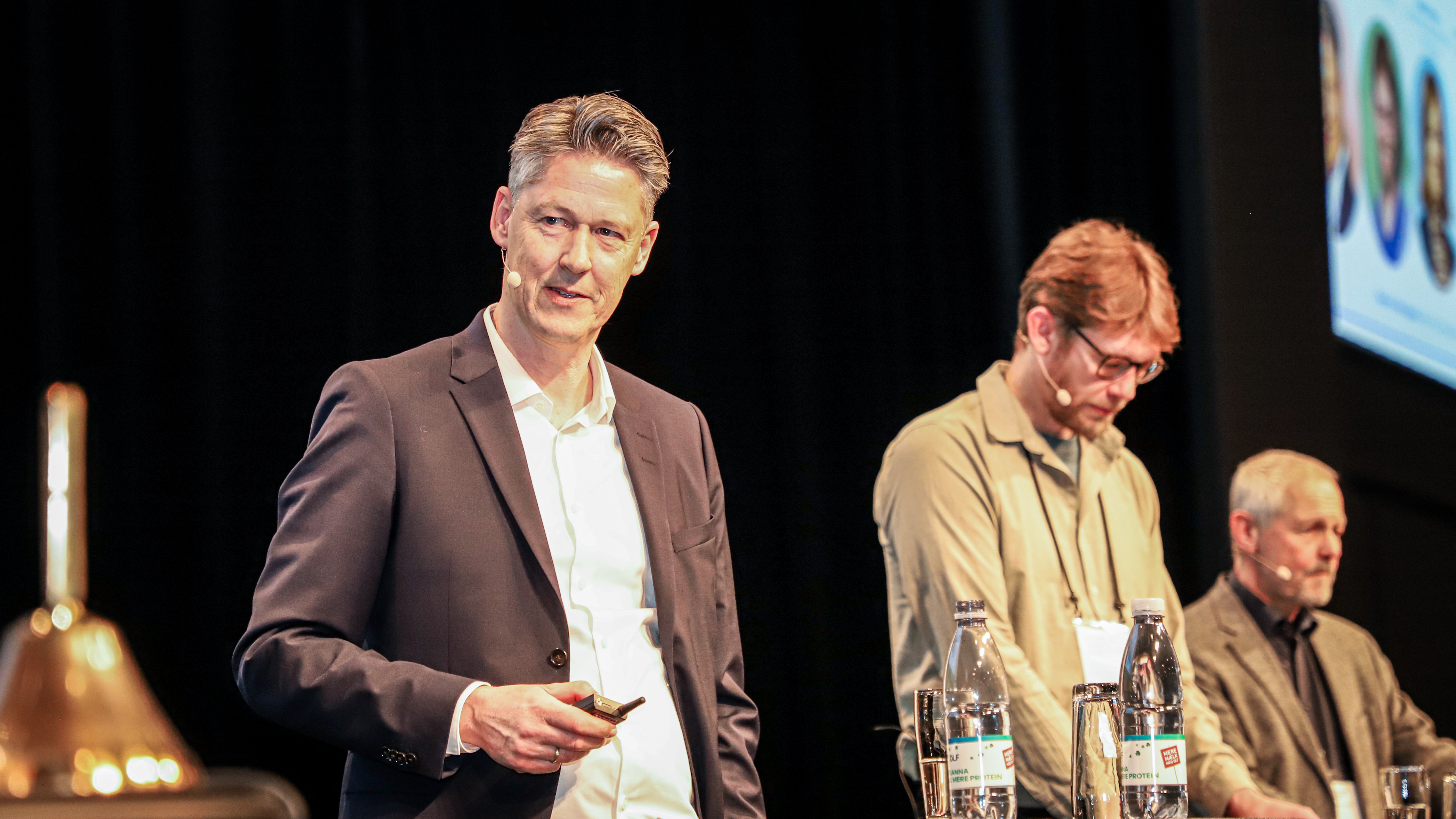 Michael Svarer står på en scene med andre paneldeltagere