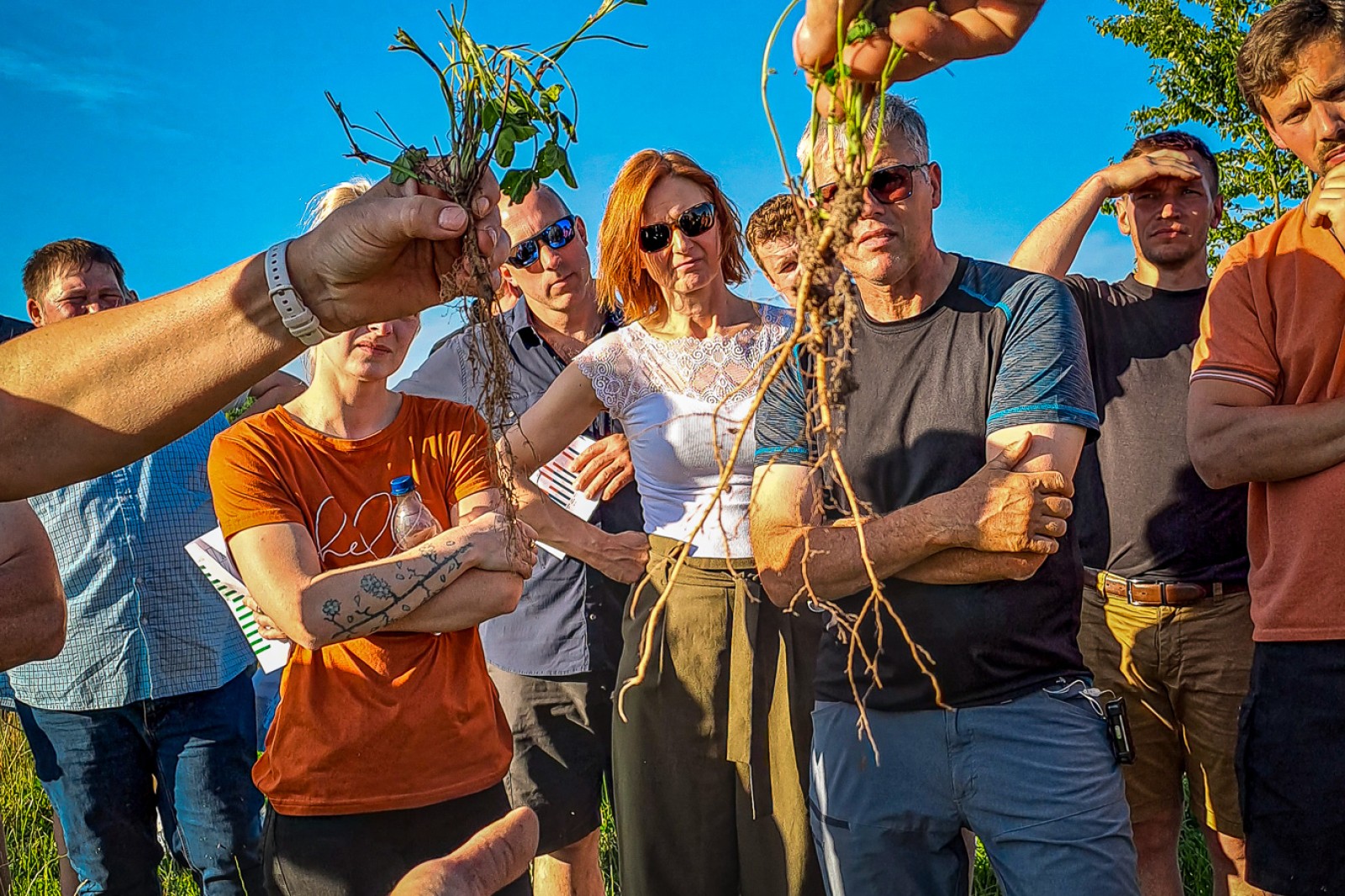 En person holder to slags planterødder op foran tilhørerne