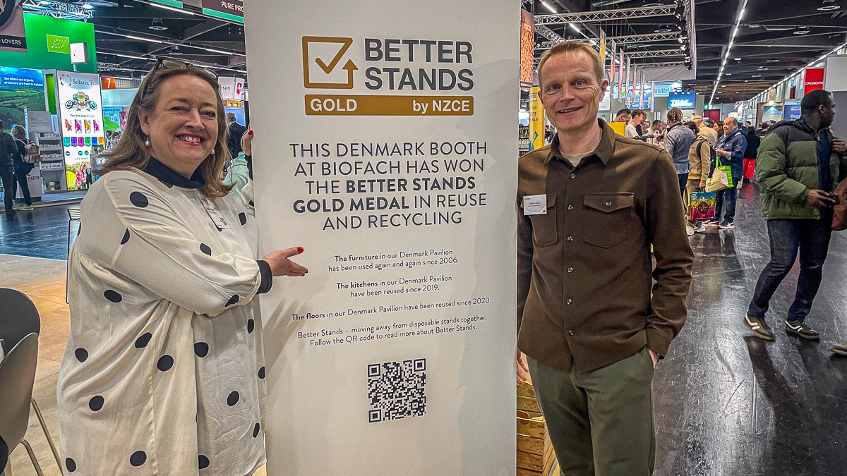 Malene Aaris og Dennis Hvam står ved guldmedaljeplakat fra Better Standsplakat