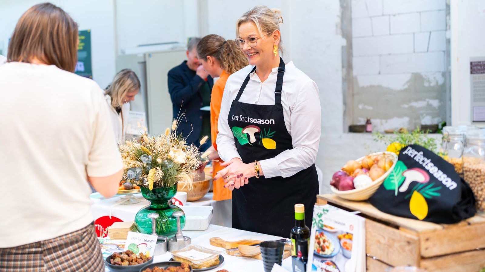 Folk prøvesmager mad ved en stand hos Perfect Season