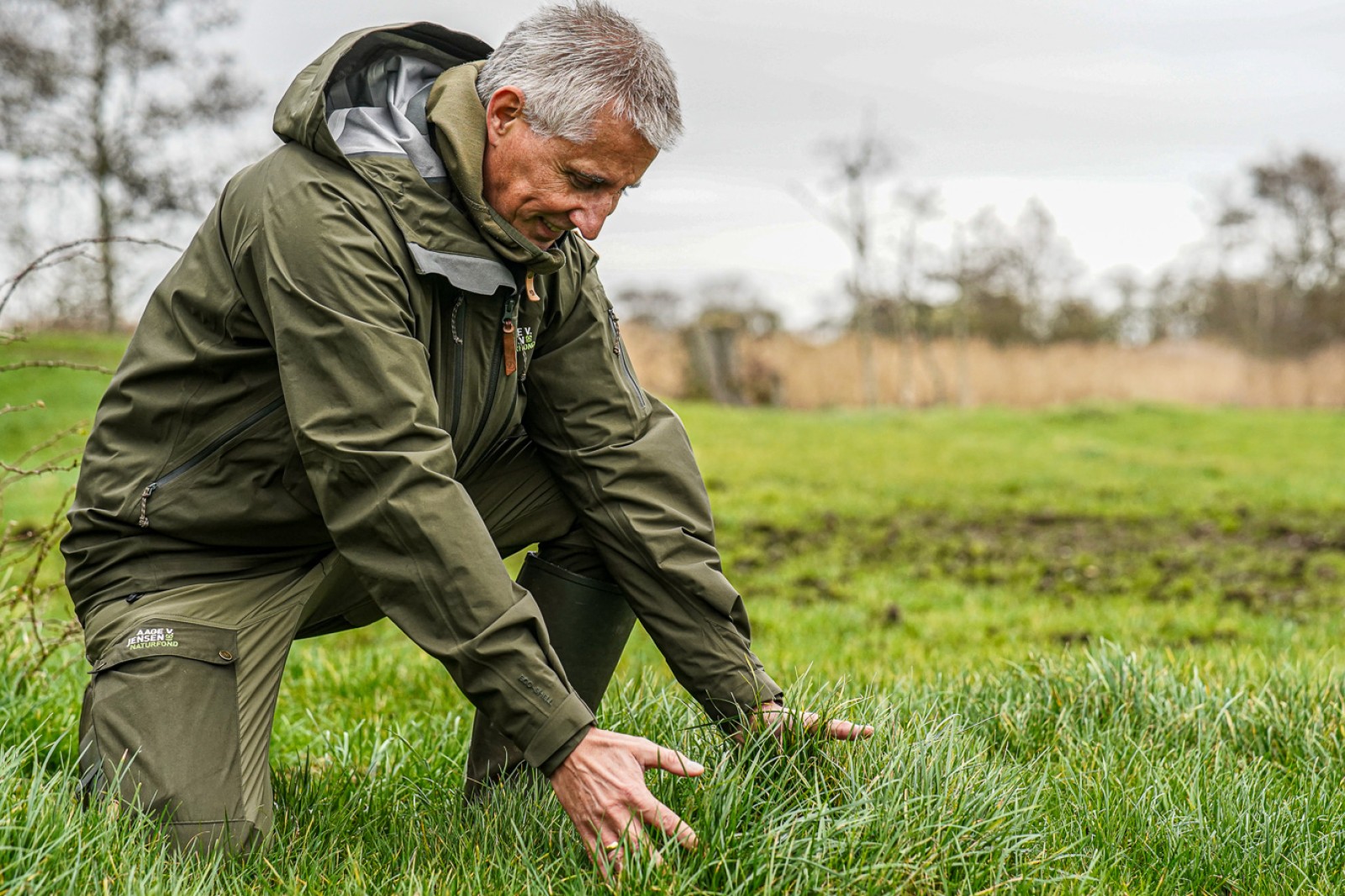 Niels Dahlin Lisborg sidder på et knæ og griber ud efter græsstrå