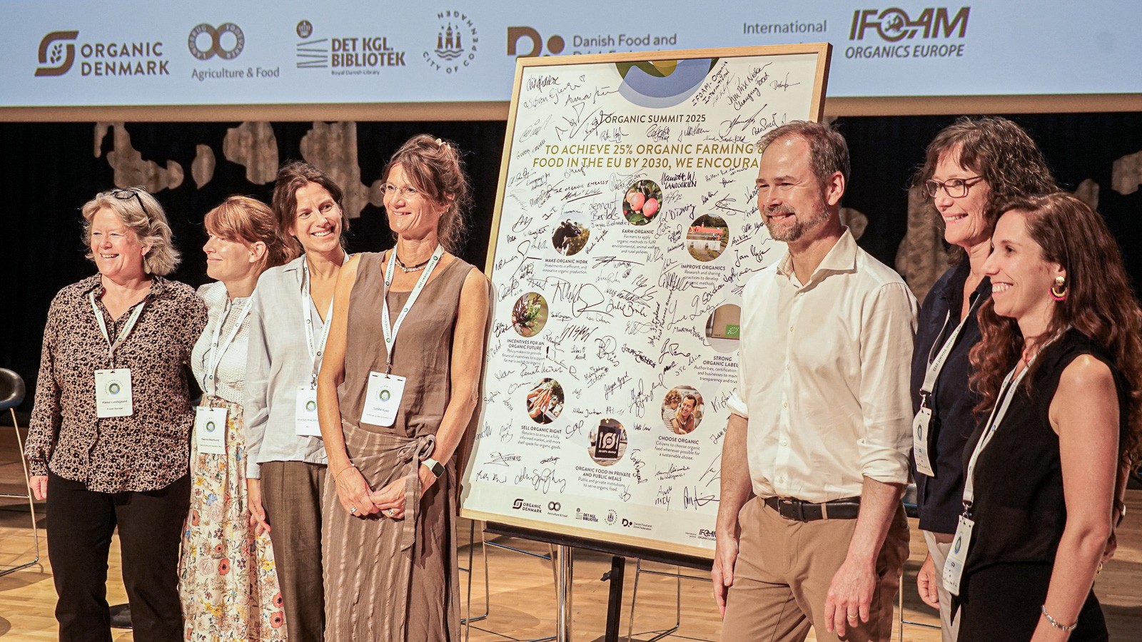 Nicolai Wammen står på scenen med medarrangørerne af Organic Summit