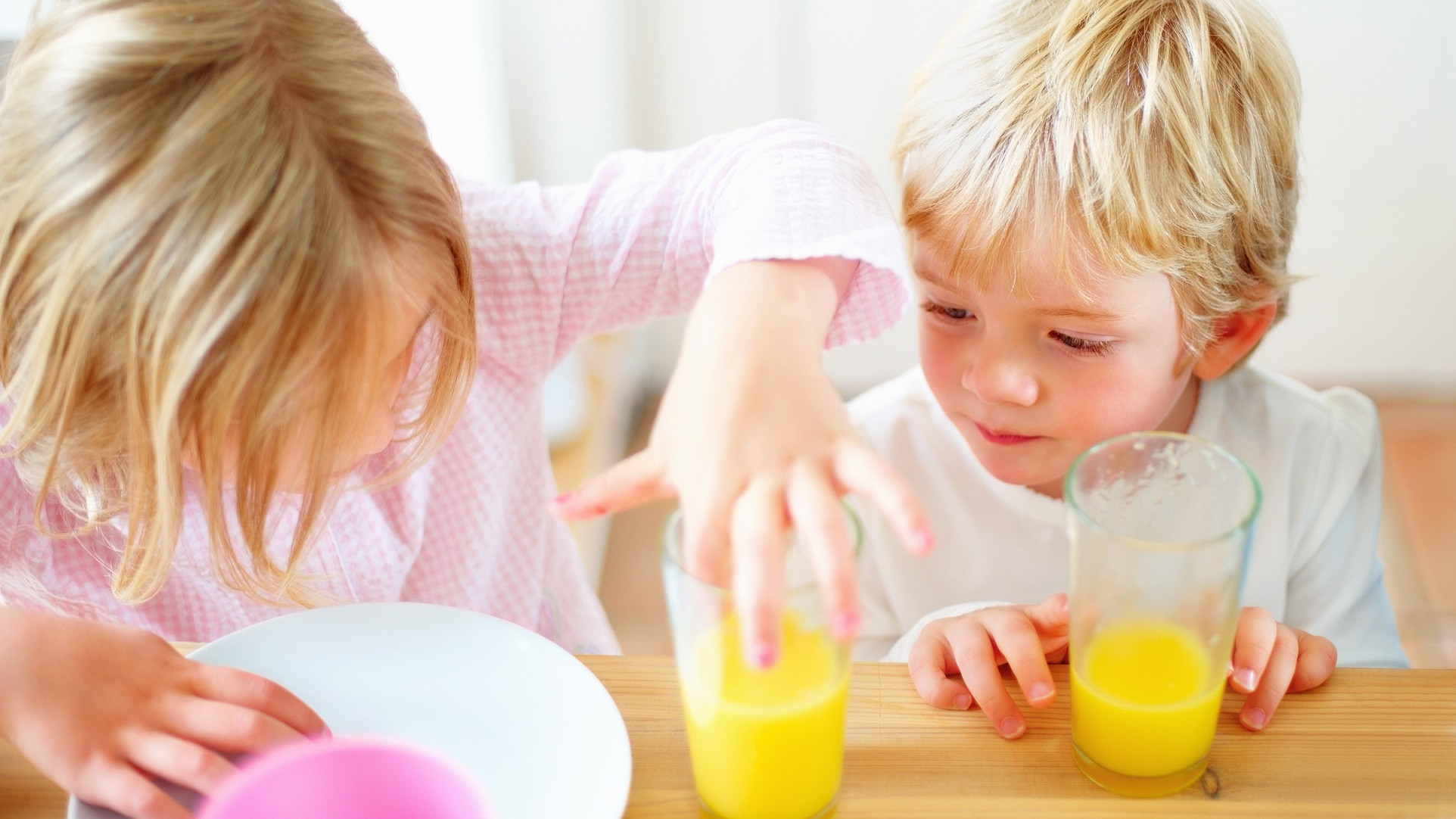 Børn leger med appelsinjuice