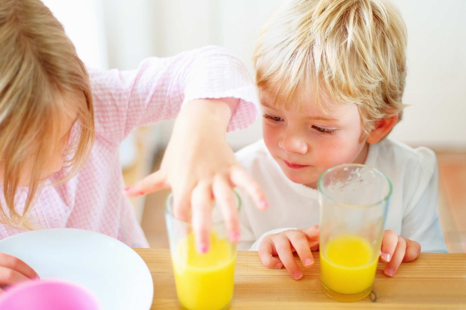 Børn leger med appelsinjuice