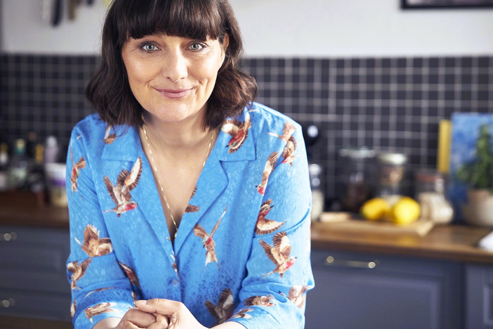 Ditte Ingemann står i et køkken og smiler til kameraet