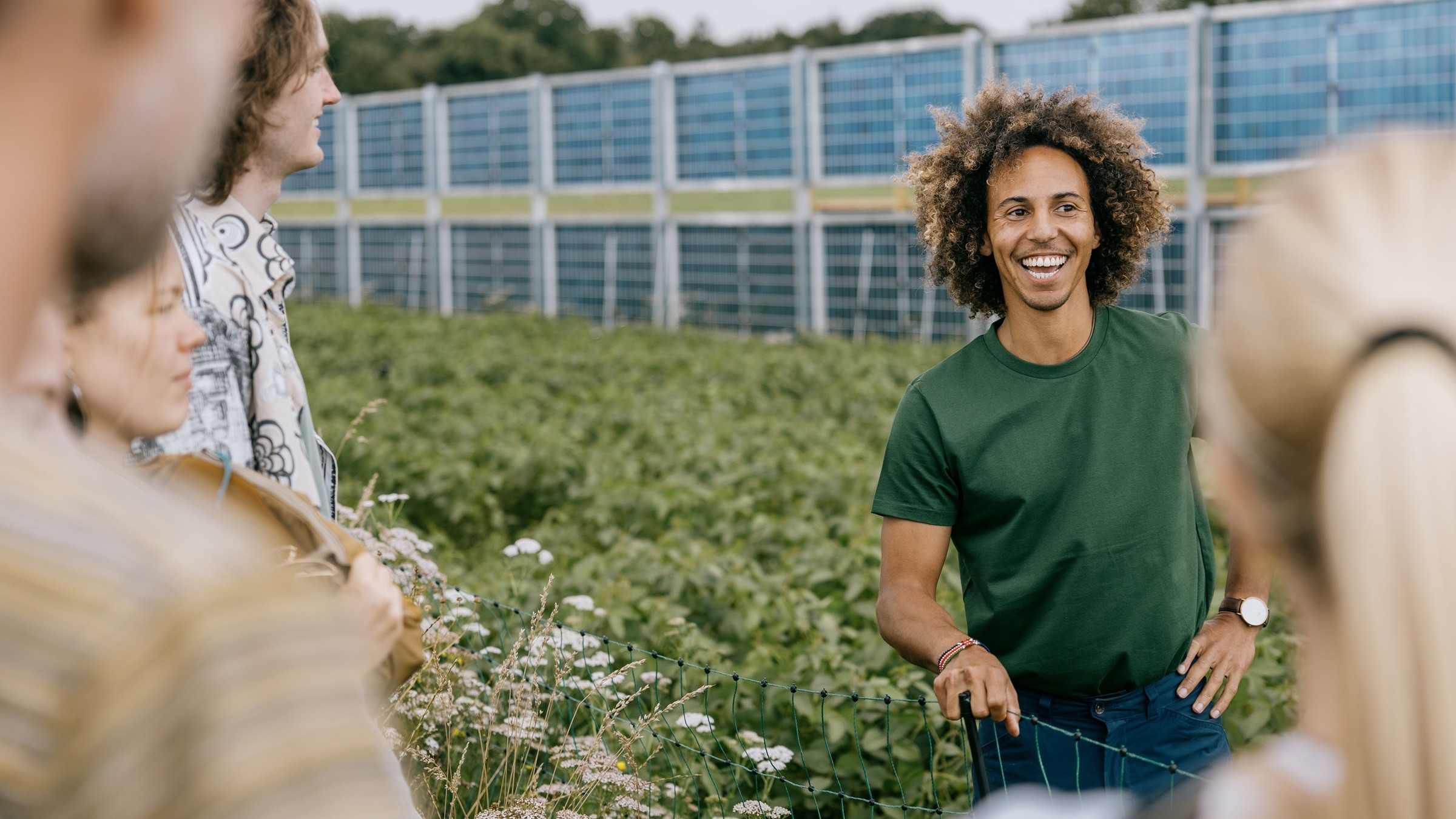 Ph.d.-studerende Kamau Lindhardt ved lodrette solpaneler på en mark ved Aarhus Universitets forskningscenter i Foulum, AU Viborg