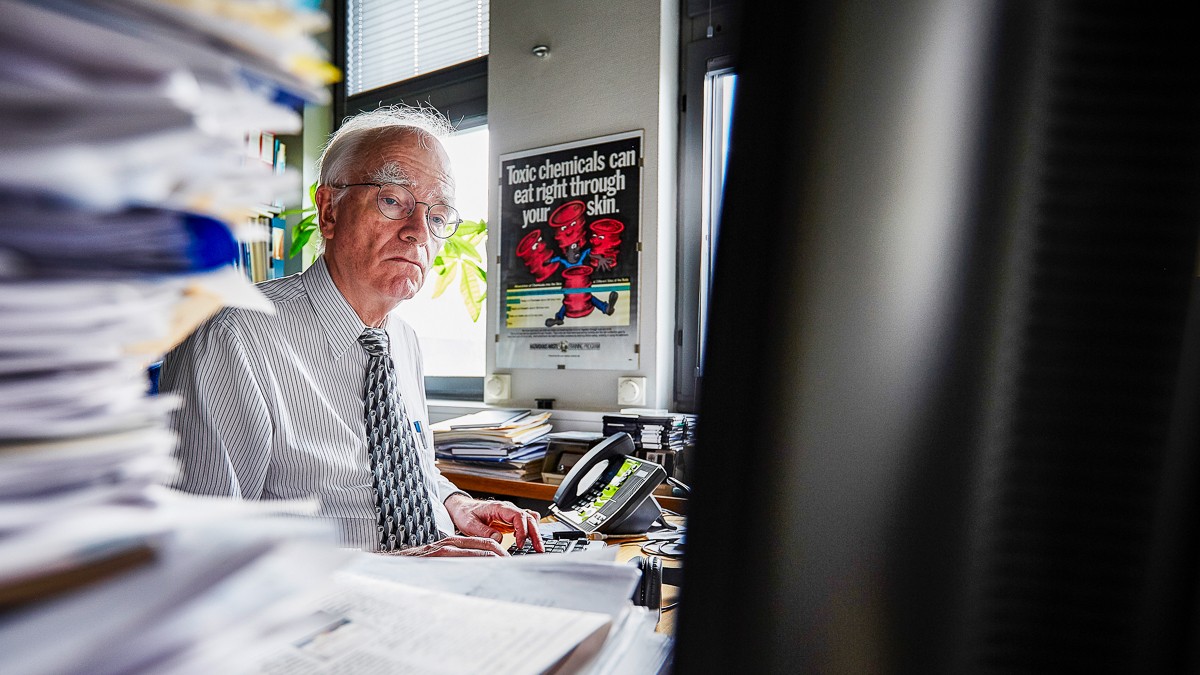 Philippe Grandjean sidder ved sit skrivebord bag stakkevis af dokumenter