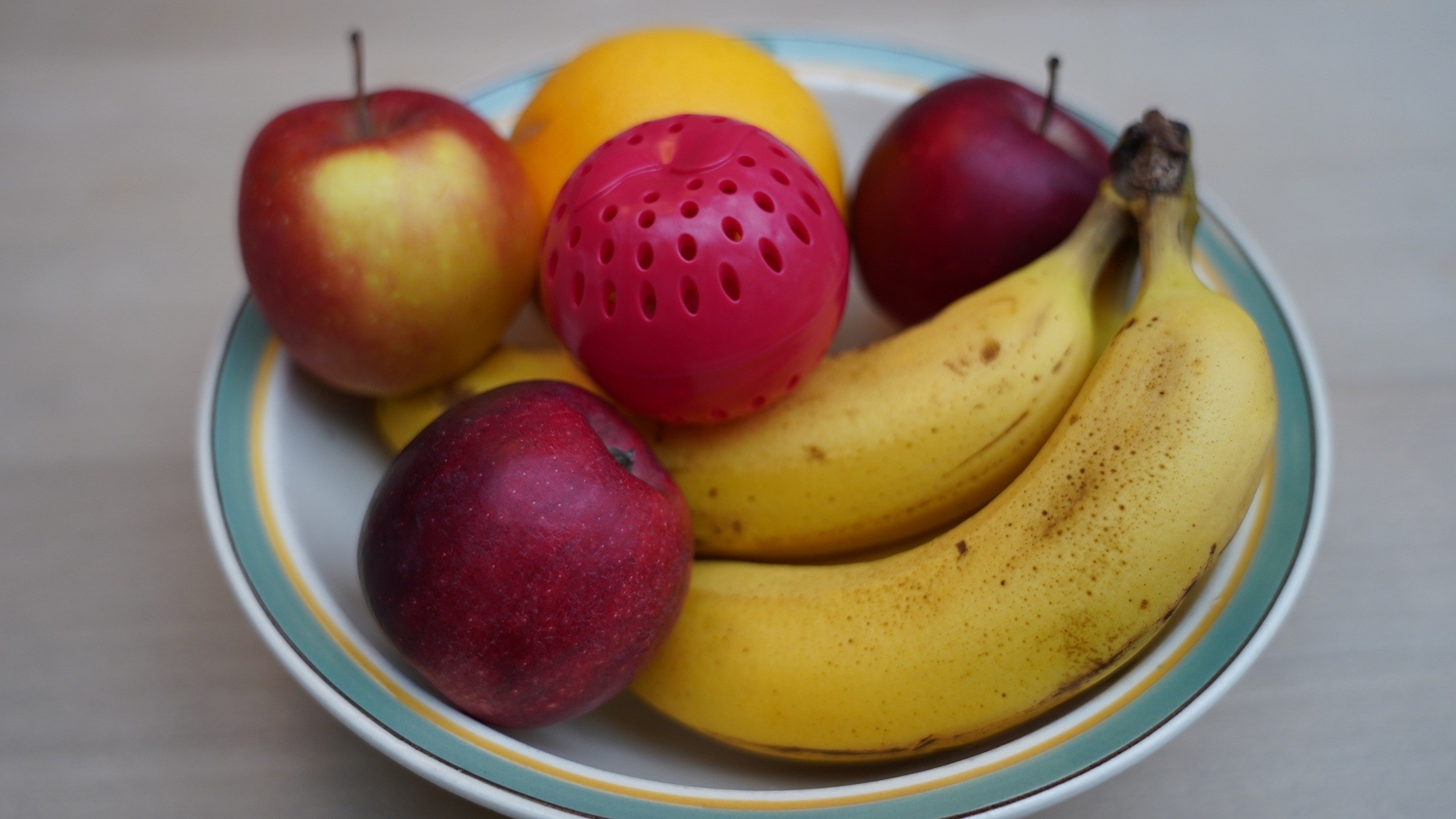 Frugtskål med frugter og en rød madspildsbold