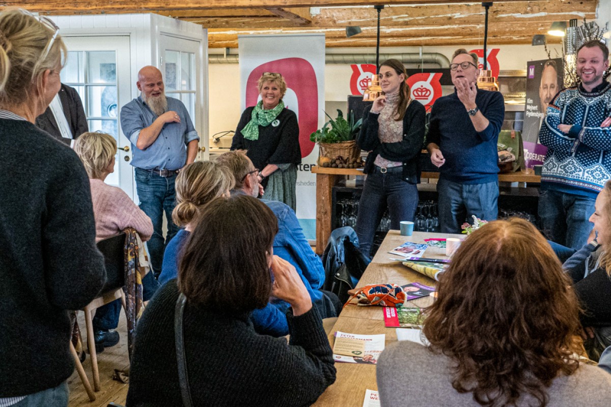 Politikere står og debatterer foran publikum