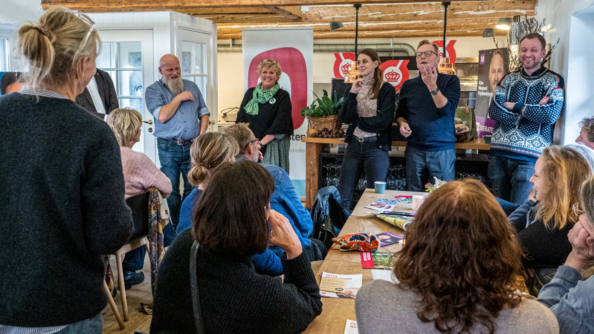 Politikere står og debatterer foran publikum